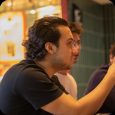 Uma jovem ruiva segurando um livro enquanto outro jovem ruivo o ajuda em sua leitura.