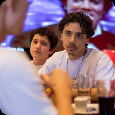 Jovens sentados em cadeiras discutindo sobre seus livros.